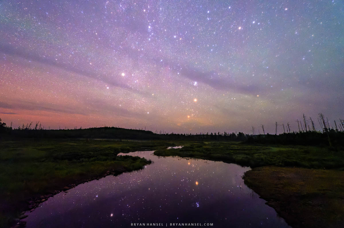 A curved stream reflection the stars above it on the Gunflint Trail during a photo workshop